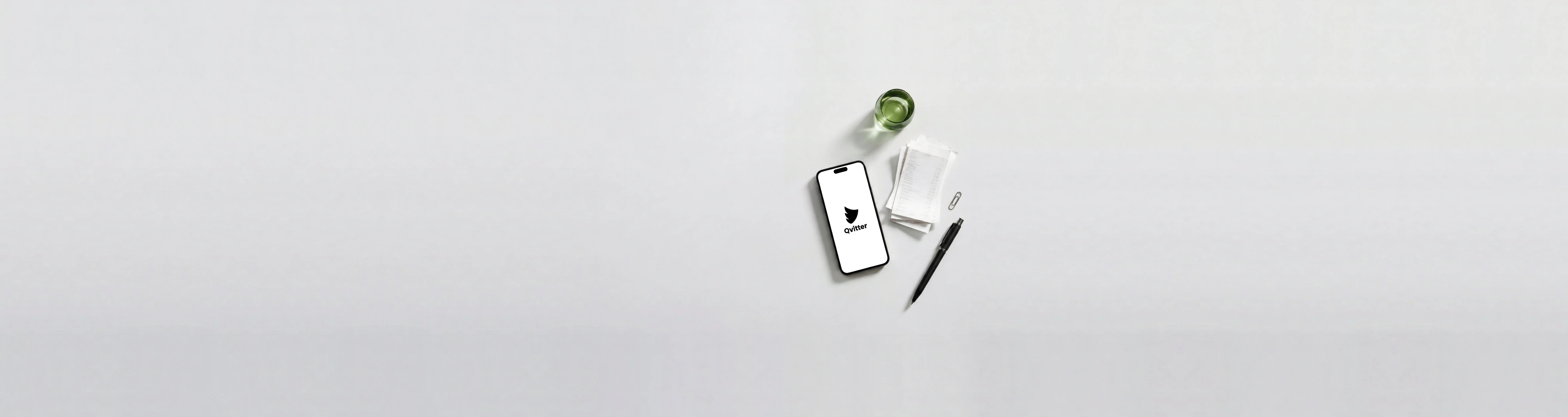 Qvitters logotyp på en telefon bredvid kvitton och en penna på ett ljust skrivbord